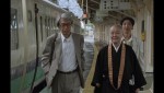 ドキュメンタリー映画『全身小説家』より、微笑みながら並んで歩く瀬戸内寂聴と井上光晴、そしてその少し後ろを追いかける形で光晴の妻・郁子