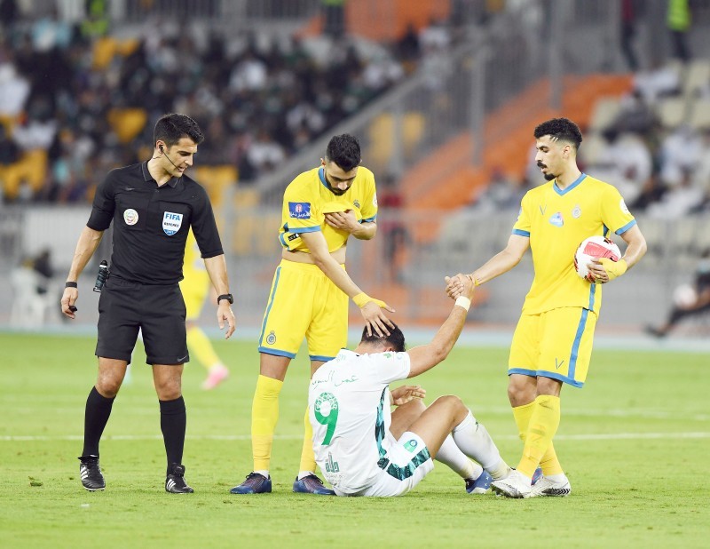 



مدافعا النصر محمد آل فتيل وعلي لاجامي في لحظة روح رياضية مع نجم الأهلي عمر السومة عقب سقوطه. (تصوير: جميل الحارثي)