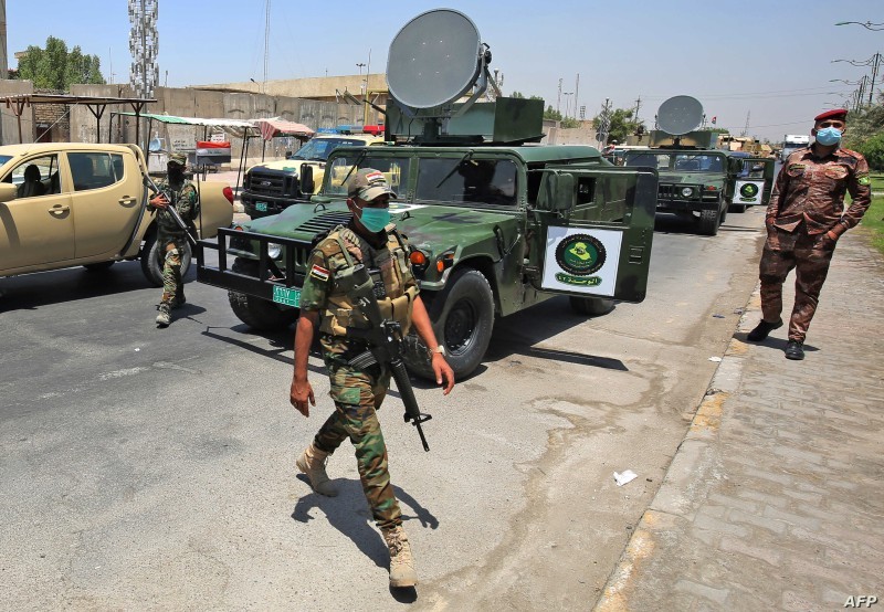 Vehicles of the Iraqi army block the entrance to the capital Baghdad's suburb of Sadr City on May 21, 2020, during a COVID-19 testing campaign as part of measures taken by the authorities aimed at containing the spread of the novel coronavirus. - Certain neighbourhoods in the Iraqi capital Baghdad began a full lockdown for two weeks as of yesterday, in reaction to a spike in coronavirus infections since restrictions were relaxed. (Photo by AHMAD AL-RUBAYE / AFP)