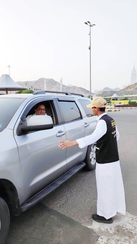 



     متطوع يرشد أحد المعتمرين في مكة.