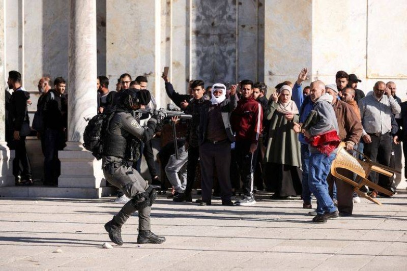 جندي إسرائيلي يصوب سلاحه نحو فلسطينيين قرب المسجد الأقصى