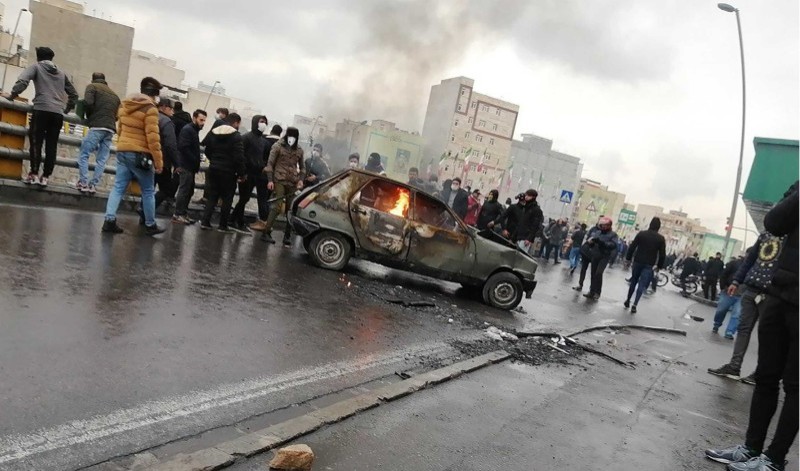 Iranian protesters gather around a burning car during a demonstration against an increase in gasoline prices in the capital Tehran, on November 16, 2019. - One person was killed and others injured in protests across Iran, hours after a surprise decision to increase petrol prices by 50 percent for the first 60 litres and 300 percent for anything above that each month, and impose rationing. Authorities said the move was aimed at helping needy citizens, and expected to generate 300 trillion rials ($2.55 billion) per annum. (Photo by - / AFP)